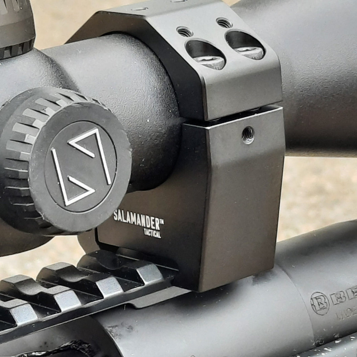 Black rifle scope secured in scope rings on a Picatinny rail