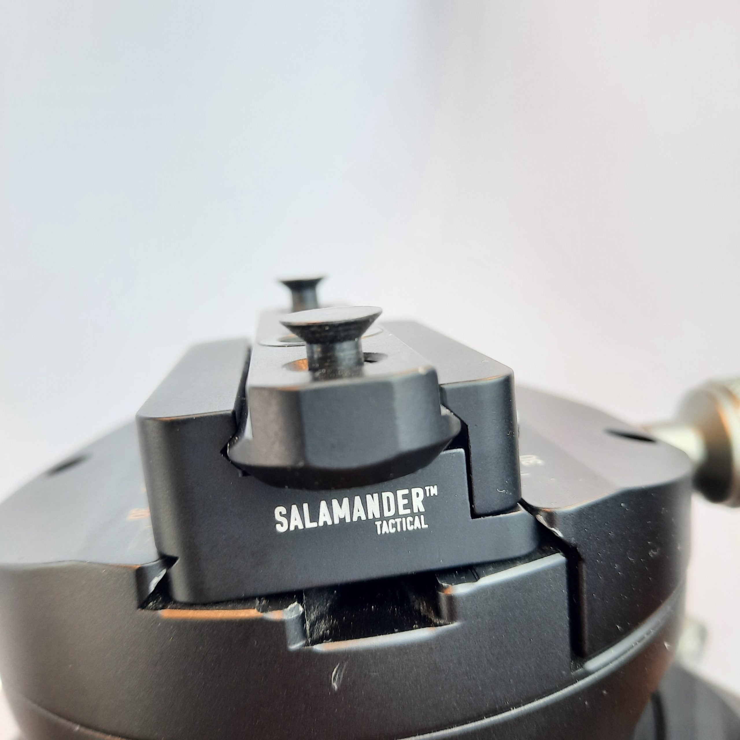 Close-up view of a Salamander Tactical mounting component for Picatinny to Arca rail adapter