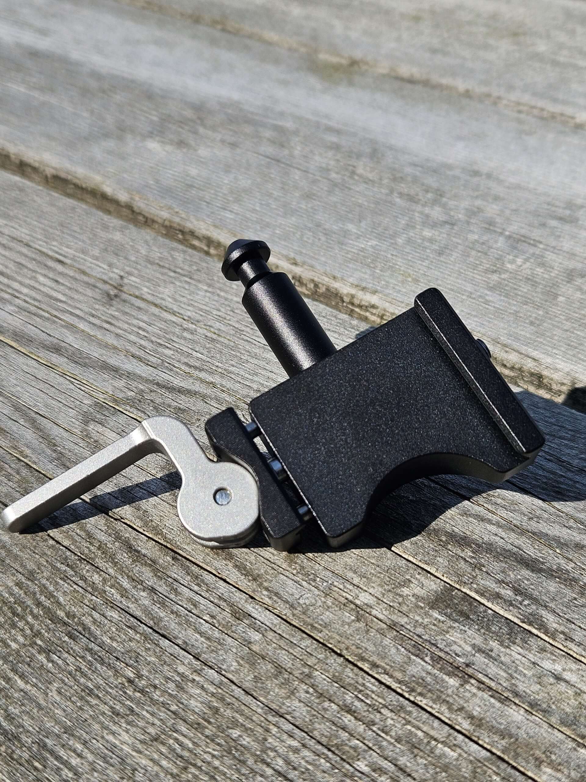 Salamandertactical QD arca to Valhalla spigot adapter on wooden surface, showcasing its sleek design and functionality.