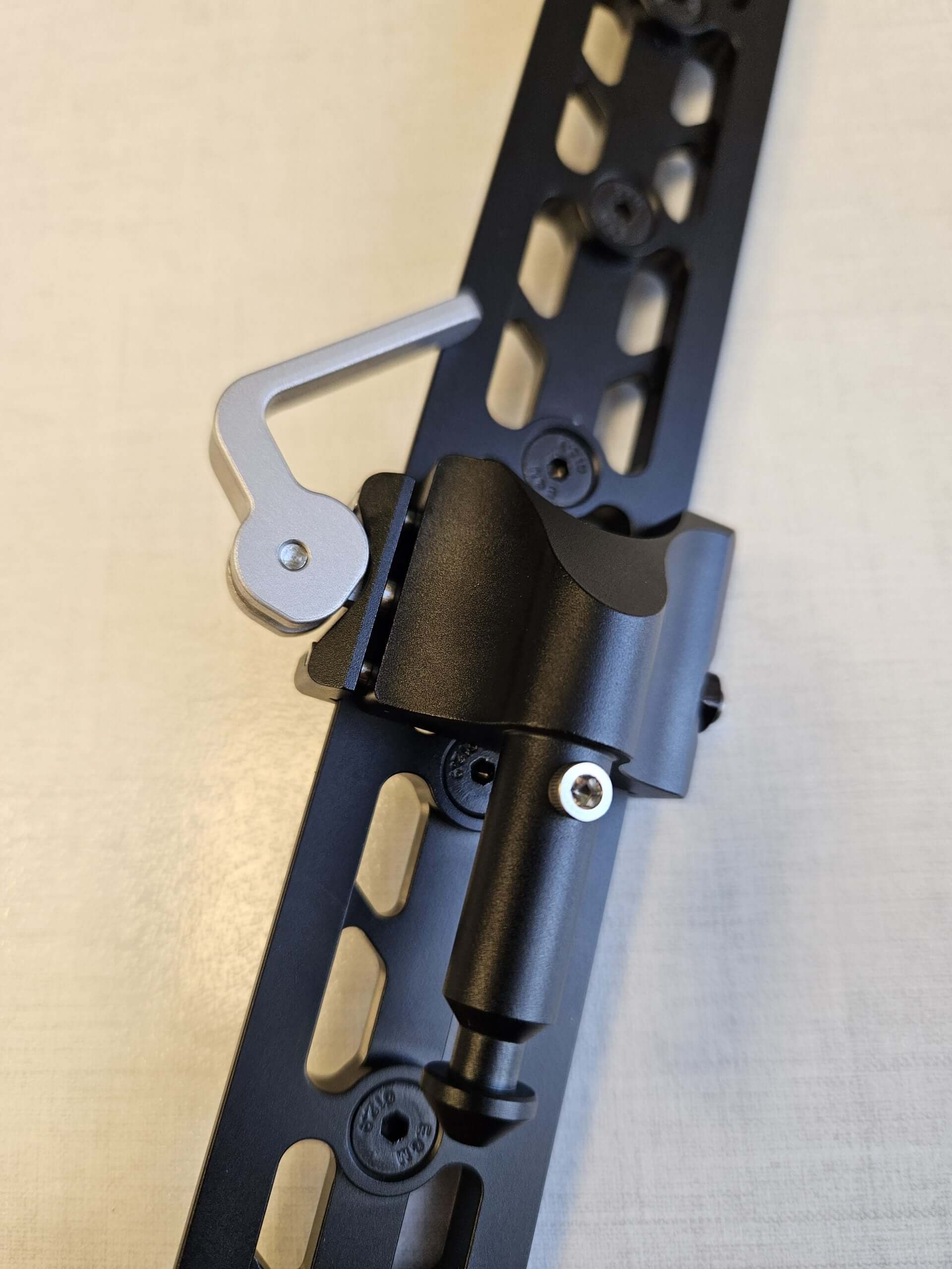 Close-up of Salamandertactical QD arca to Valhalla spigot adapter mounted on an Arca-compatible rail.