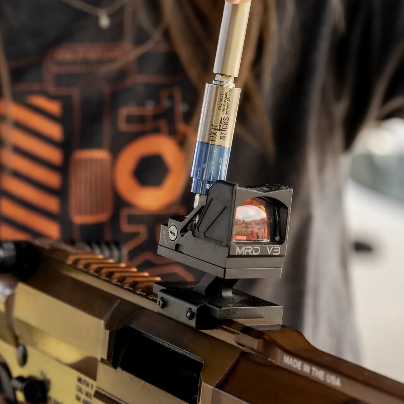 Using the Mini All-in-One Torque Driver for precise adjustments on a firearm optic.