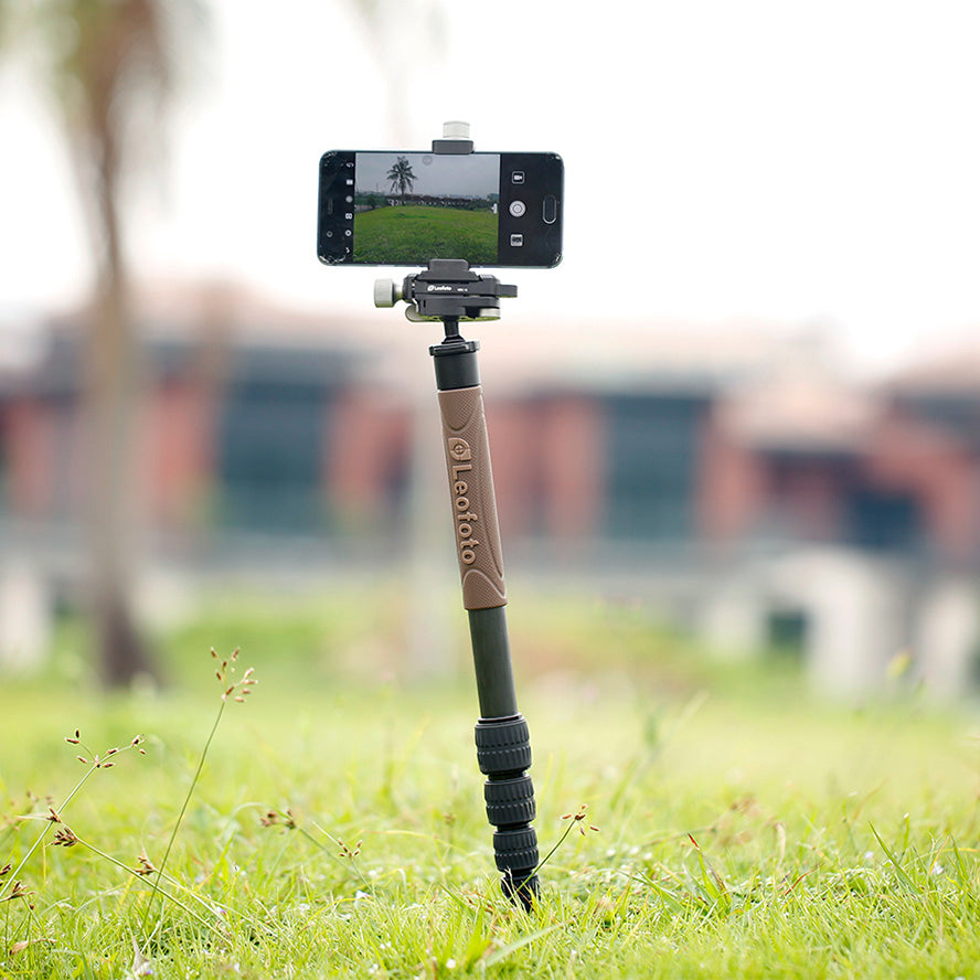 Leofoto GO-125 Monopod supporting a smartphone in an outdoor setting with blurred background.