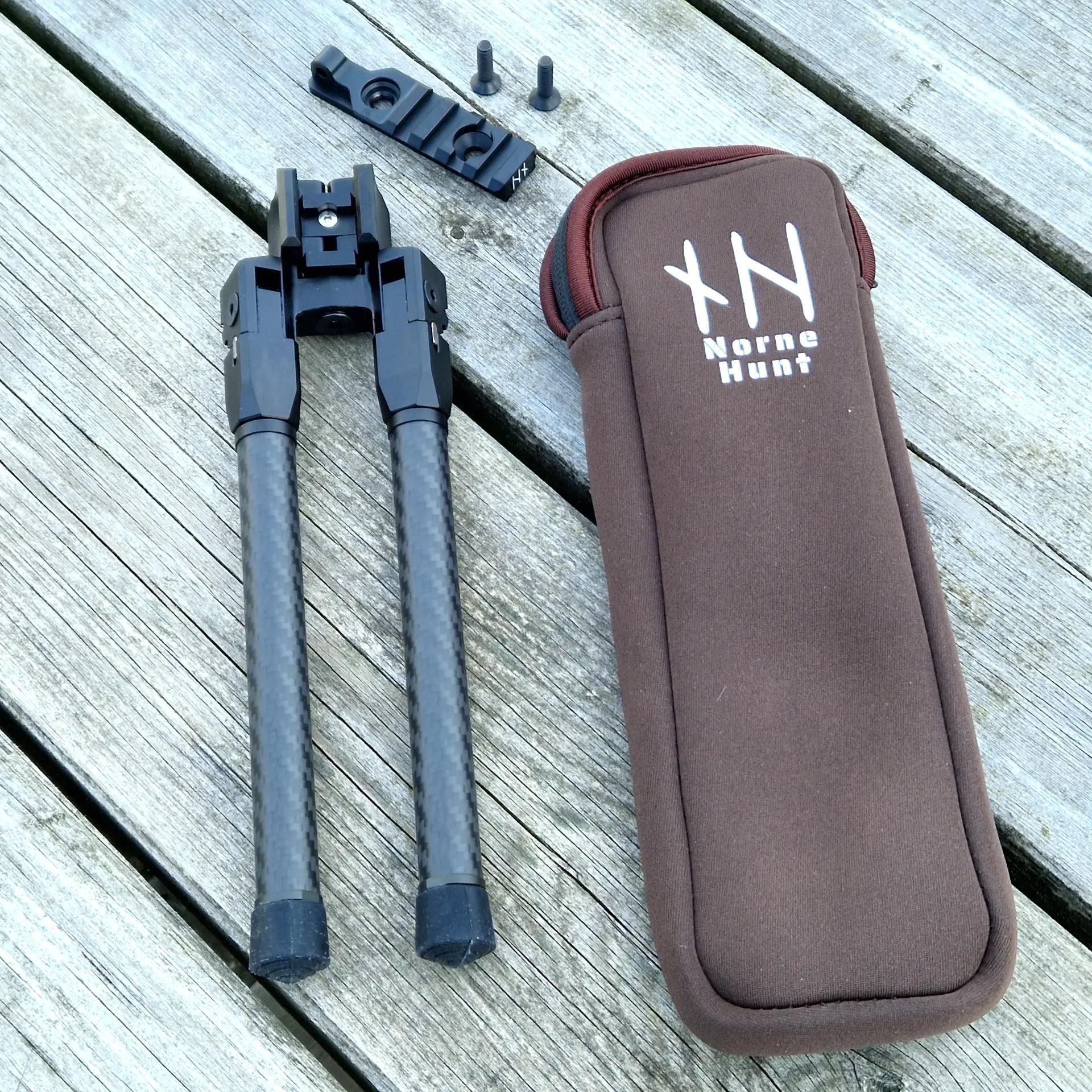 NorneHunt bipod and mounting plate displayed on a wooden surface beside a branded brown protective pouch, showing included screws and accessories.