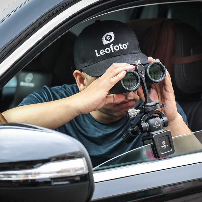 Man observing through binoculars using WN-01+SW-01 car window clamp kits from inside a vehicle.
