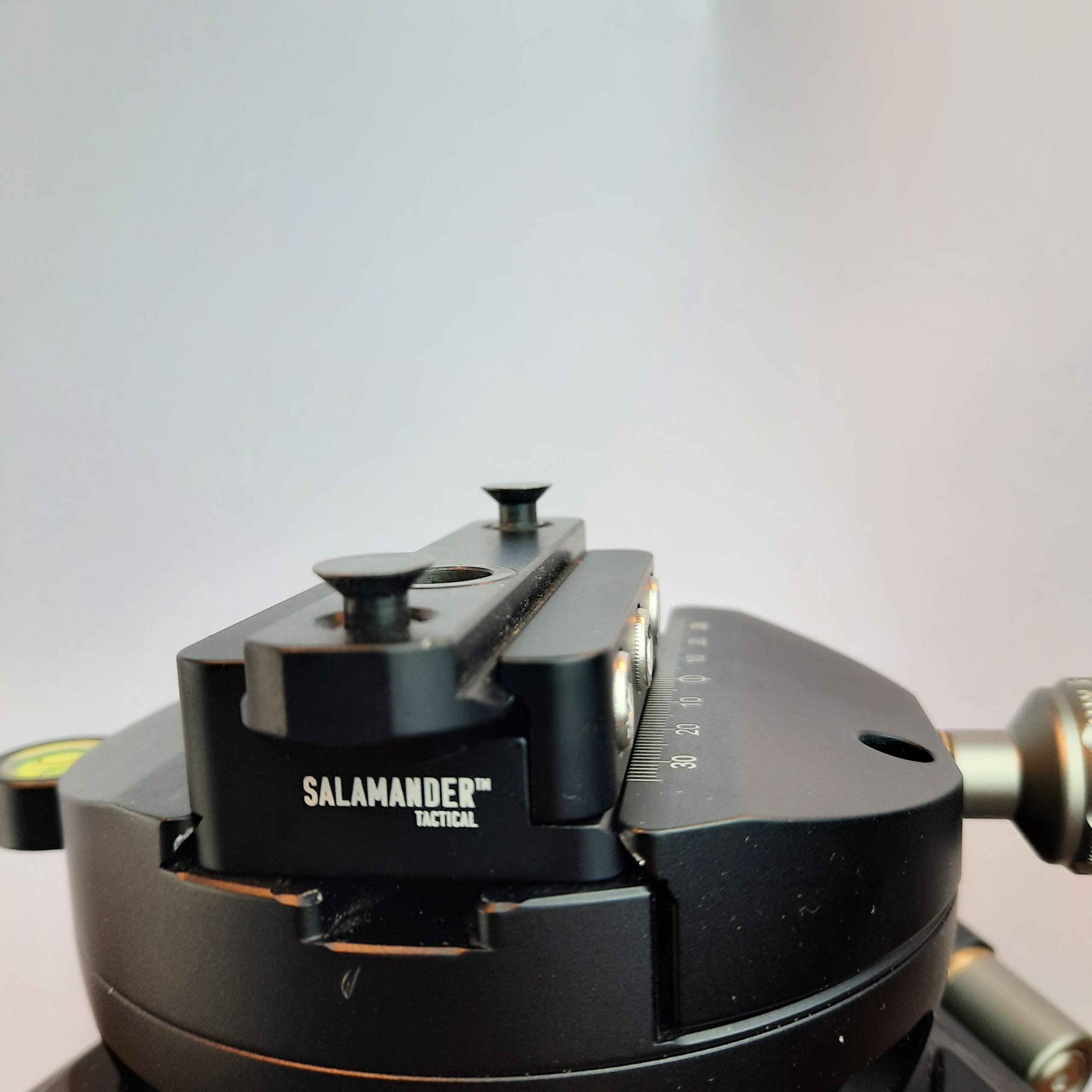 Close-up of a Salamander Tactical mount with a Picatinny to Arca rail adapter for seamless rifle setup.