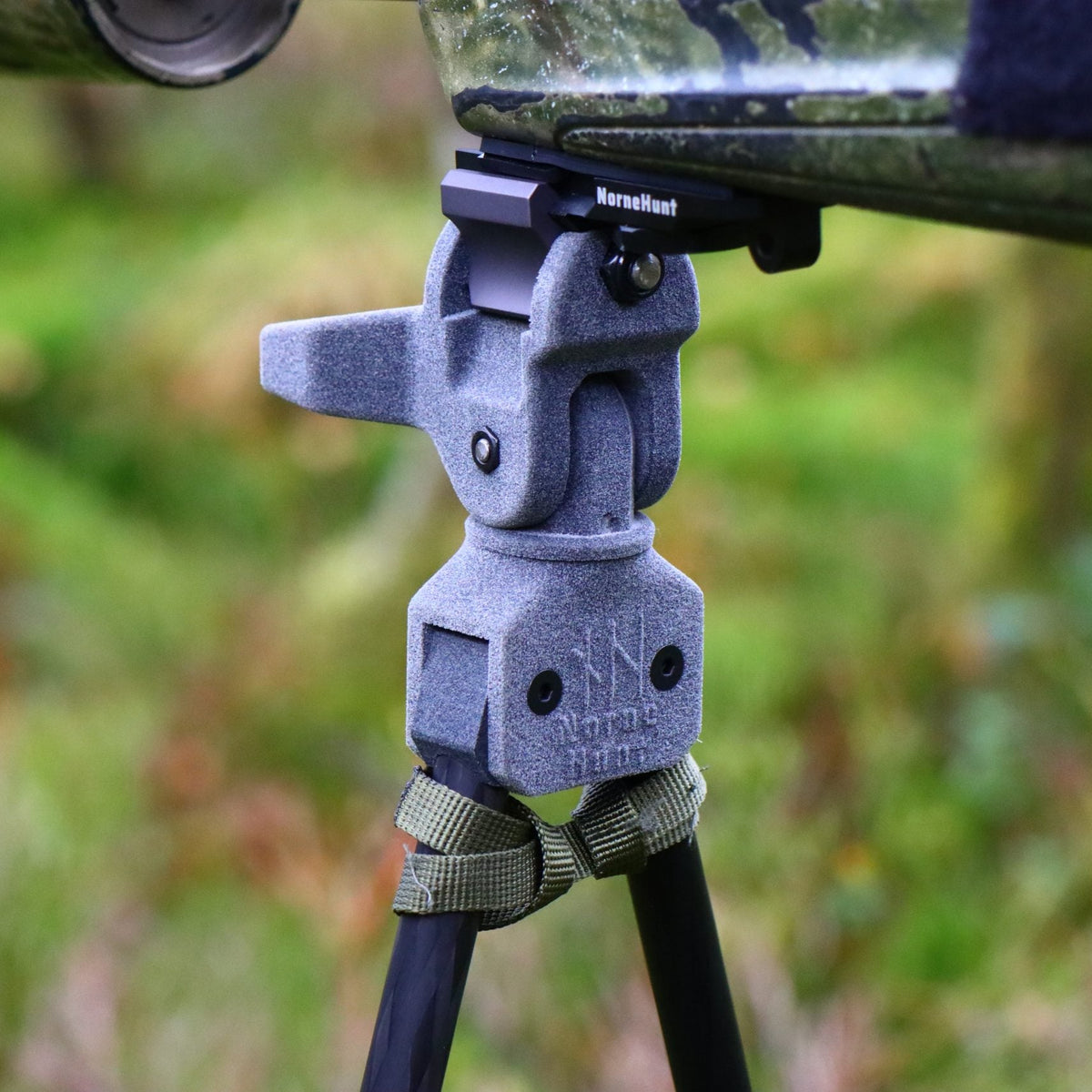 NorneHunt Picatinny rail fitted beneath a camouflage rifle stock and connected to a shooting stick head.